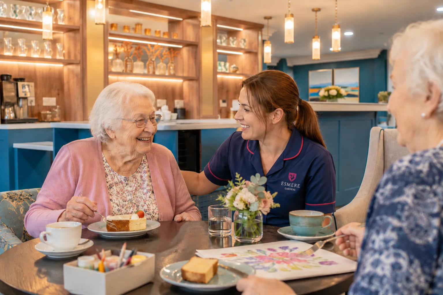 Residents and an Esmere Gardens team member enjoying afternoon tea together